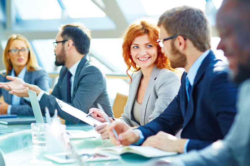 Pretty young employee looking at her colleague during discussion of data